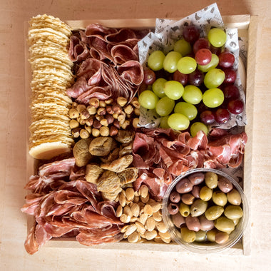 charcuterie platter with an assortment of meats, nuts, and fruits