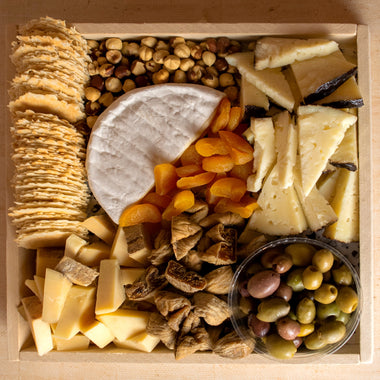 Classic Cheese Platter featuring a variety of cheeses, crackers, nuts, dried fruits, and olives