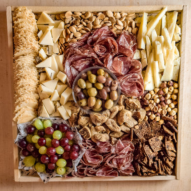 Deluxe Cheese and Charcuterie Platter with various types of cheese, meats, nuts, olives, and fruits
