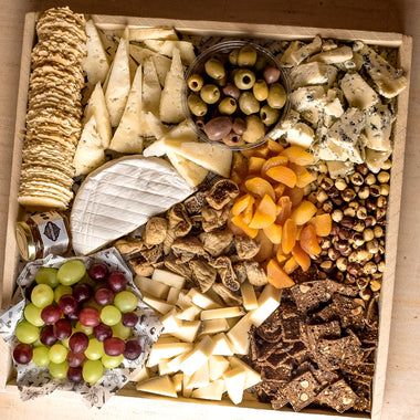 Deluxe Cheese Platter featuring a variety of cheeses, fruits, and crackers