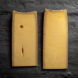 saxelby cheesemongers connoisseur's club fall selection - two different wedges of the same cheese on a cheese board at different ages