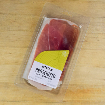 mitica sliced prosciutto on wooden cutting board