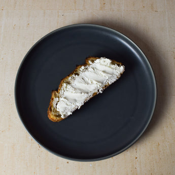 Emerson Farmer's Cheese spread on crispy bread. Fresh cow's milk cheese from Woodlawn Creamery.