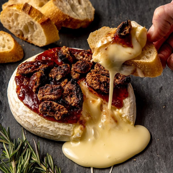 Baked Brie set - a gooey cheese toasted with nuts and strawberry jam with sliced baguettes